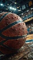 Basketball resting on damp wooden floor in an indoor sports arena during an exciting match in the late evening hours photo