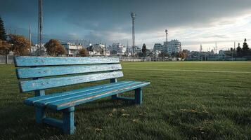 Bench overlooking an empty football field under cloudy sky in a quiet urban neighborhood photo