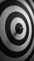 Circular target with a dart embedded in the center, showcasing precision and focus in a black and white color scheme photo