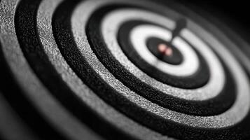 Close-up view of a dartboard with concentric circles in a monochromatic design emphasizing focus and precision photo