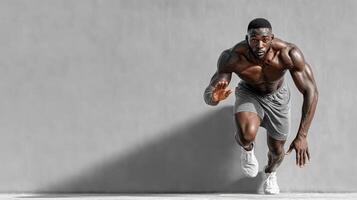 Runner training at high intensity against a gray wall during the day in an urban environment photo