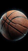 Basketball spinning in mid-air against a dark background with water droplets capturing the sport's dynamic motion photo