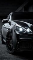 Sleek black luxury car parked in an industrial setting at night highlighting its striking design and powerful presence photo