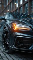 Sleek black sports car parked at an urban location with modern architecture in the background during twilight hours photo