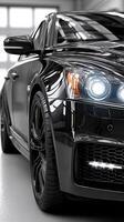 Black luxury car parked in a bright garage with polished floor, showcasing sleek design and intense headlights during daytime photo