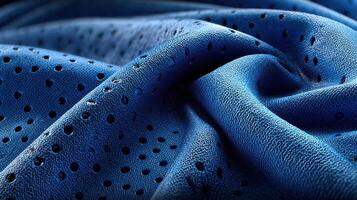 Close-up view of textured blue fabric with perforations showcasing light and shadow in a soft and intricate pattern photo