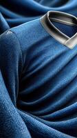 Detailed close-up of a textured blue sports jersey with a black collar showcasing intricate fabric design photo