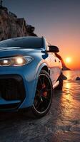 Luxury car parked by the ocean during sunset with vibrant colors reflecting on the sand photo