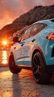 Car parked by the shore at sunset with vibrant colors reflecting on the water photo