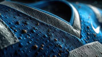 Close-up view of blue soccer shoe showcasing texture and details under dramatic lighting photo