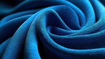 Soft blue fabric swirls elegantly, showcasing texture and depth under natural lighting conditions photo