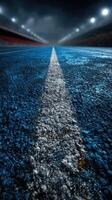 Long empty road under a dramatic sky at night with bright lights illuminating the distance photo