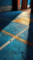 Old indoor court with blue and orange markings and sunlight creating striking shadows in the afternoon photo