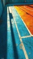 Colorful urban sports court with sunlit lines and shadows during afternoon photo