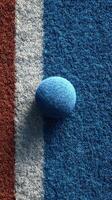 Deep blue textured sphere on a colorful surface representing a sports court during an outdoor game photo