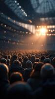 Crowd gathers in excitement as lights illuminate a stadium during a vibrant event at dusk photo