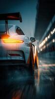 Race car speeding through wet track at night with vibrant lights illuminating surroundings photo
