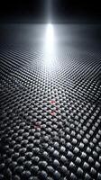 Reflective textured surface with a bright light source illuminating a dark environment at an abstract angle photo