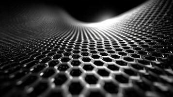 Hexagonal pattern of a metallic mesh creating an abstract surface in black and silver tones photo