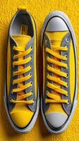 Bright yellow sneakers on a vibrant yellow background highlighting modern footwear design and style in a creative composition photo