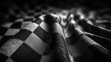 Textured black and white checkered fabric drapes elegantly on a flat surface in an artistic arrangement photo