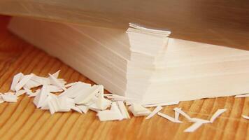 Satisfying ASMR white paper cutting on wooden surface with paper pile video
