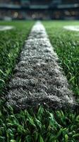Close-up view of a well-maintained football field with a focus on the yard line and lush green grass in an indoor stadium setting photo