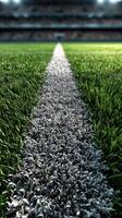 Green grass field with white line leading to stadium seating during a sports event at dusk photo