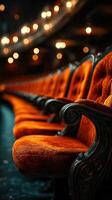Elegant theater seats lined in rich orange with warm lighting creating a cozy atmosphere during an evening performance photo