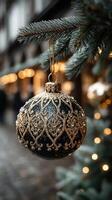 Festive holiday ornament hanging on a pine branch with twinkling lights in the background during a winter evening photo