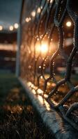 Sunset glimmers through a soccer goal net at a stadium with wet grass and a vibrant atmosphere photo