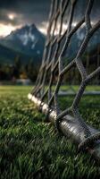 Sunset over a mountain soccer field with goalpost and net shimmering in the light photo