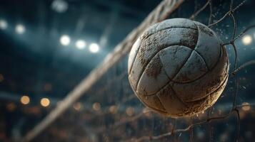 Volleyball caught in the net during a competitive match in an indoor arena filled with spectators at night photo