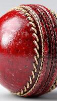 Red cricket ball close up highlighting texture and stitching for sports enthusiasts and players photo