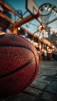 Basketball resting on ground in vibrant urban market during early evening with soft lights twinkling above photo