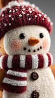Cute snowman figurine wearing a red sweater and hat with snowflakes, presenting a festive winter look on a grey background photo