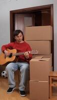 A man playing a guitar in front of boxes video