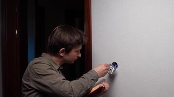 Electrician installing light switch and reading instructions manual video