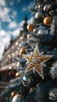 Golden star ornament on a festive Christmas tree in a decorated public square during winter celebrations photo