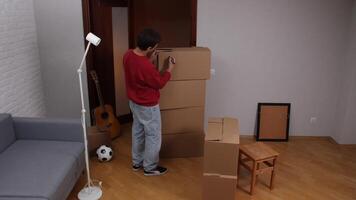 Man labeling cardboard boxes in new apartment after moving in video