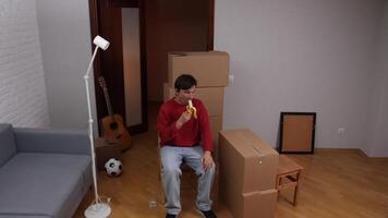 Man eating banana taking break during moving house day video