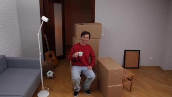 Man drinking coffee while relaxing during move to new home video