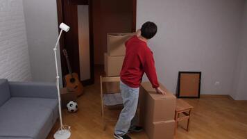 Man packing cardboard boxes in new apartment during moving day video