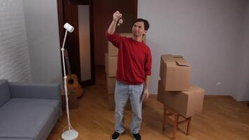Happy man showing keys of new apartment after moving in video