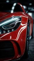 Close-up view of a sleek red sports car showcasing its detailed design and glossy finish in a dimly lit garage photo