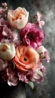 Colorful bouquet of flowers showcasing peonies, cherry blossoms, and ranunculus arranged in a dark vase photo