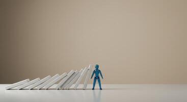 Blue Figure Stopping Falling Dominoes photo
