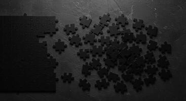 Black puzzle pieces on dark surface photo