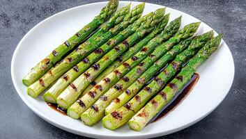 Grilled Asparagus on White Plate with Sauce photo
