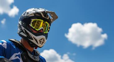 Close up low angle view of a motocross man wearing helmet and goggles photo